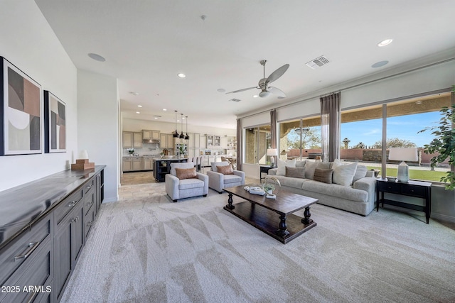 carpeted living room with ceiling fan