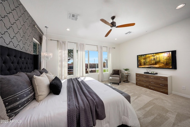 bedroom featuring ceiling fan with notable chandelier and light colored carpet