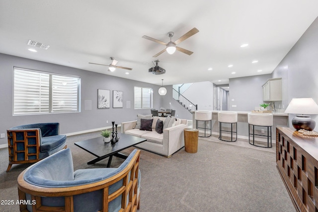 carpeted living room with ceiling fan