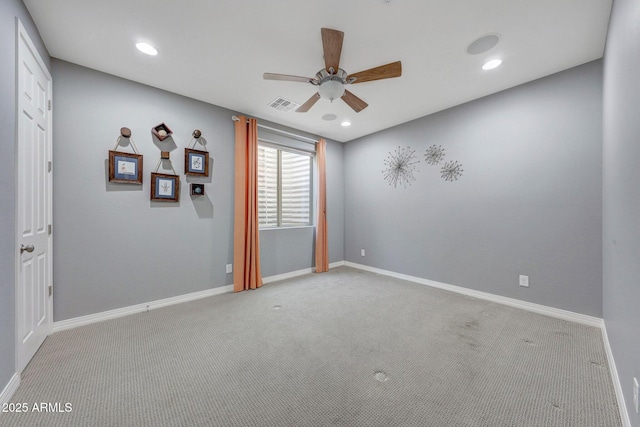 spare room featuring light colored carpet and ceiling fan