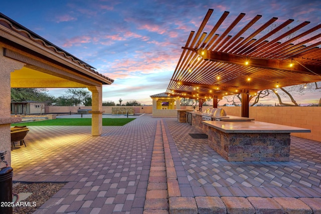 view of home's community featuring a pergola, a patio, and exterior kitchen