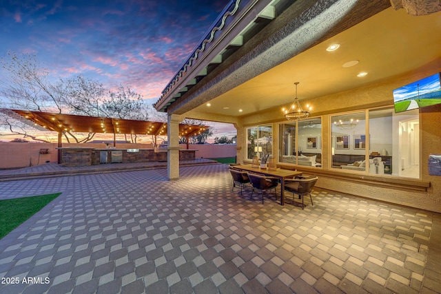 patio terrace at dusk featuring exterior kitchen