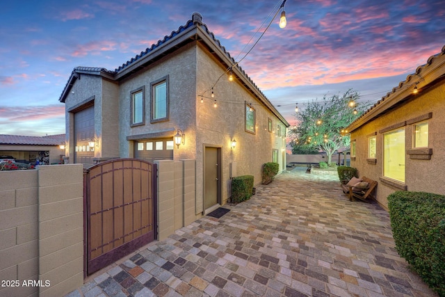 property exterior at dusk featuring a garage