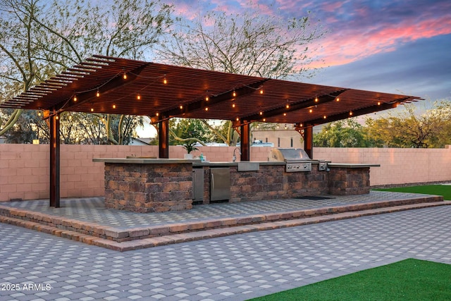 view of property's community with a pergola, a patio, and an outdoor kitchen