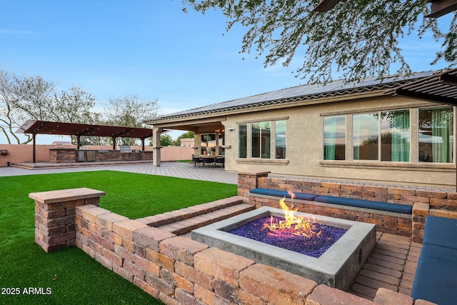 back of house with a yard, a patio, and an outdoor fire pit