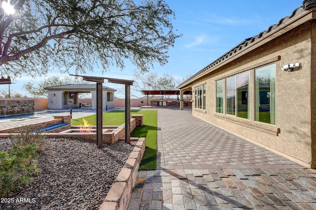 view of yard with an outbuilding, a swimming pool with hot tub, and a patio