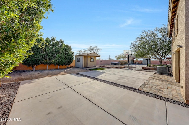 exterior space with an outdoor structure, cooling unit, and basketball court