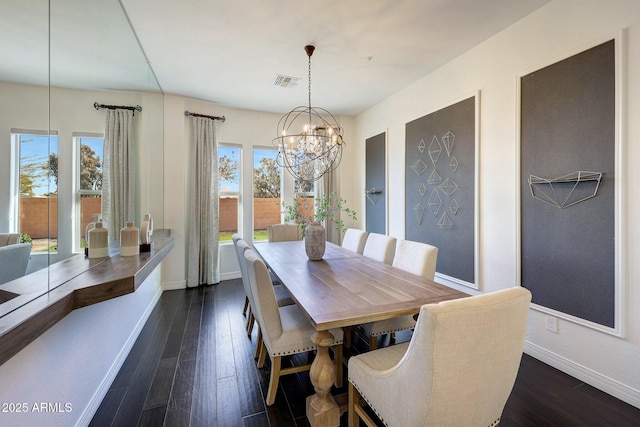 dining space featuring dark wood-type flooring and a chandelier