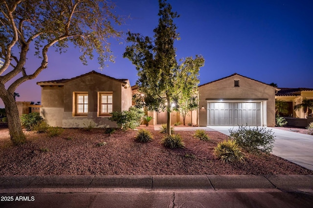 mediterranean / spanish-style house with stucco siding, an attached garage, driveway, and fence