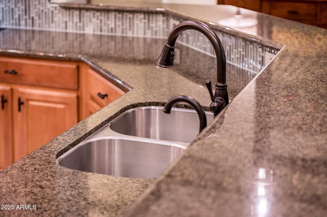 details featuring backsplash and dark stone countertops