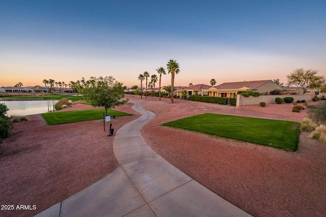 surrounding community with a lawn and a water view