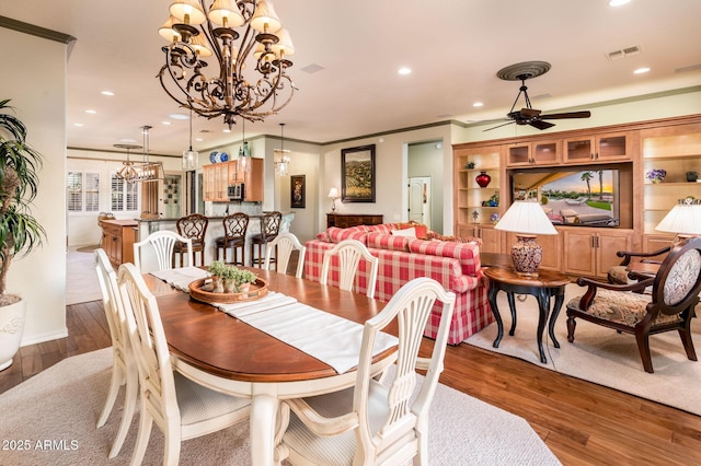 dining room with crown molding, recessed lighting, wood finished floors, and visible vents