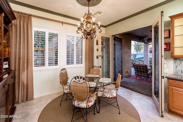 dining area with visible vents, baseboards, crown molding, and an inviting chandelier