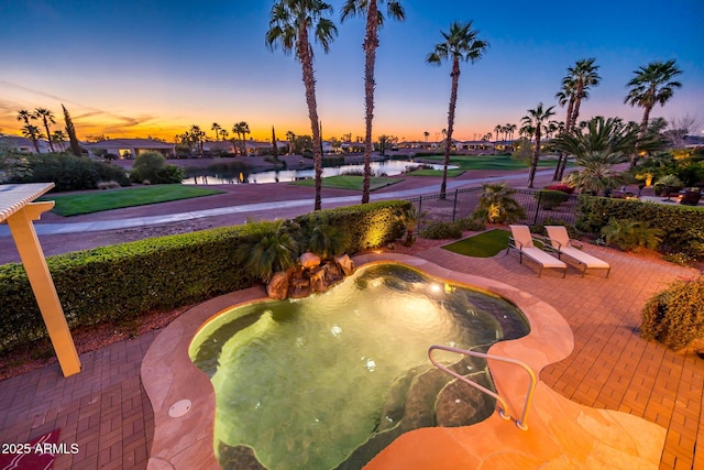 surrounding community featuring a patio area, fence, a water view, and a hot tub