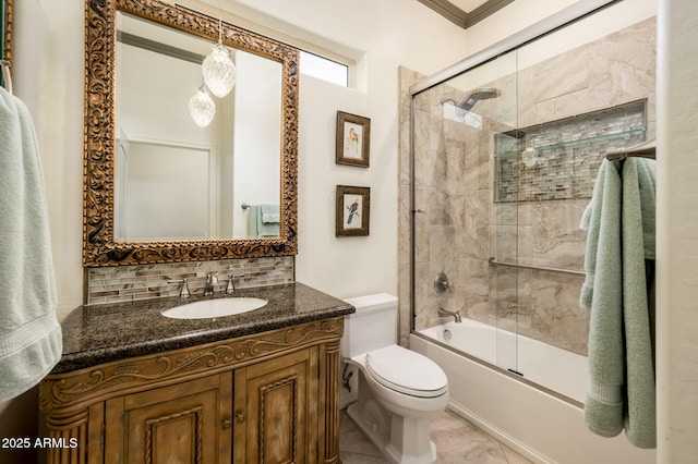 bathroom featuring combined bath / shower with glass door, backsplash, vanity, and toilet