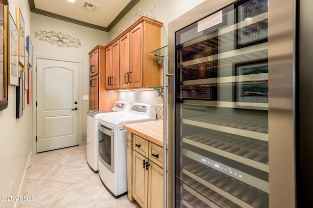 laundry area featuring visible vents, wine cooler, cabinet space, crown molding, and washing machine and clothes dryer