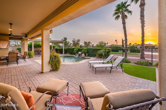 patio terrace at dusk with fence and a fenced in pool