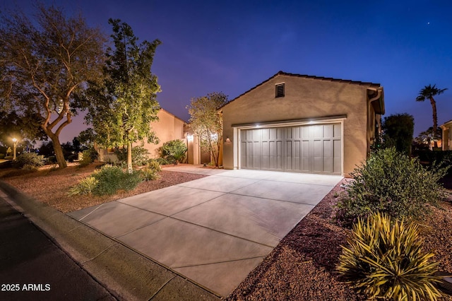 view of front of house featuring a garage, driveway, and stucco siding