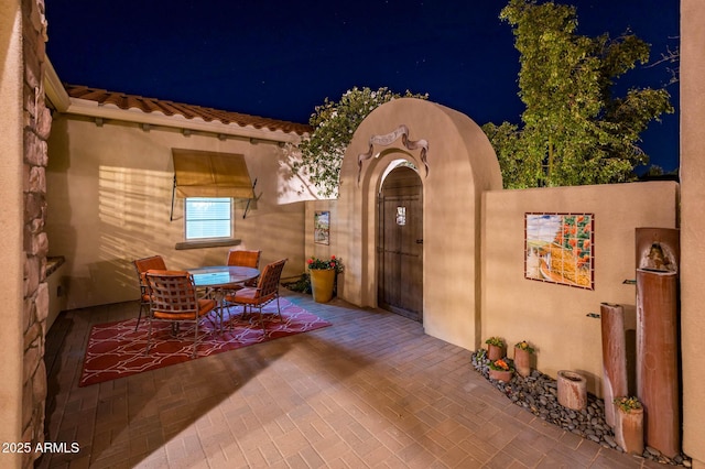 patio at night featuring outdoor dining area