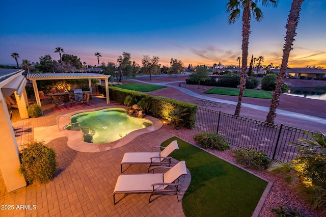 view of pool with outdoor dry bar, a lawn, a patio, and fence