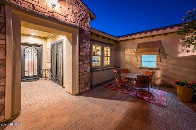 patio at night featuring outdoor dining space