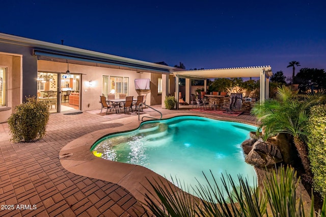 pool at night featuring a patio, outdoor dining space, and a pergola