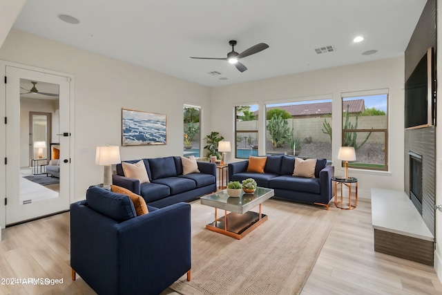 living room with ceiling fan and light hardwood / wood-style flooring