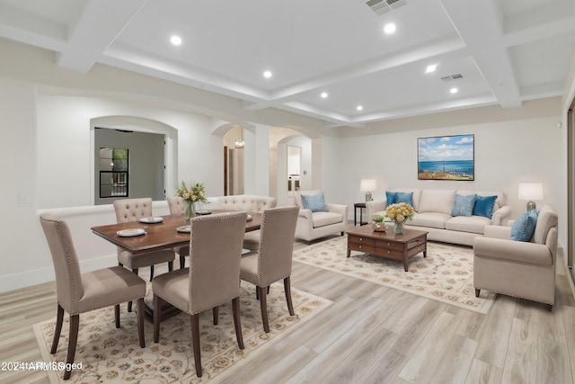 dining space with coffered ceiling, light hardwood / wood-style floors, and beamed ceiling