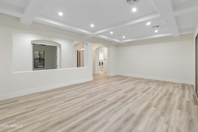 spare room featuring coffered ceiling, light hardwood / wood-style flooring, and beamed ceiling