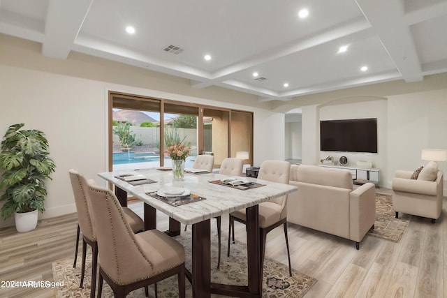 dining space with light wood-type flooring, coffered ceiling, and beamed ceiling