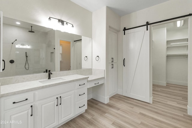 bathroom featuring hardwood / wood-style floors, an enclosed shower, and vanity