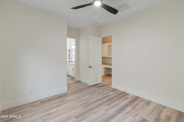 unfurnished bedroom featuring ceiling fan, light wood-type flooring, and ensuite bath