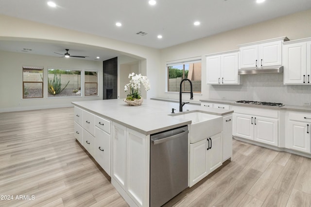 kitchen featuring a kitchen island with sink, stainless steel appliances, light wood-type flooring, ceiling fan, and white cabinets