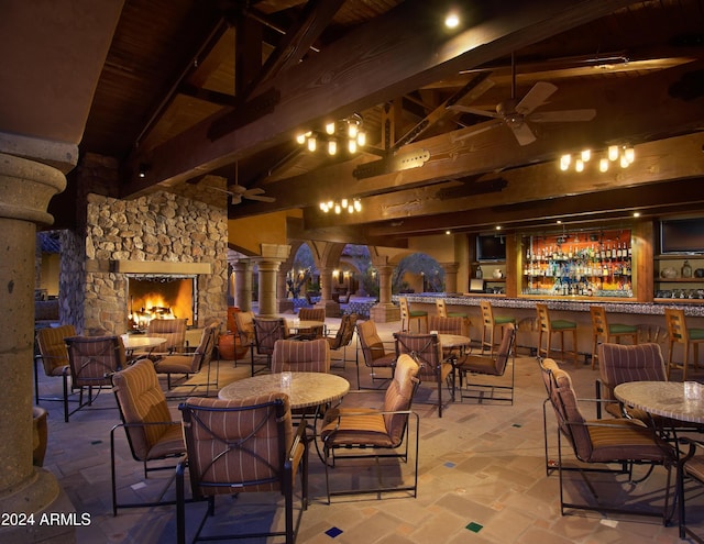 dining room with wooden ceiling, a fireplace, ceiling fan, high vaulted ceiling, and beam ceiling