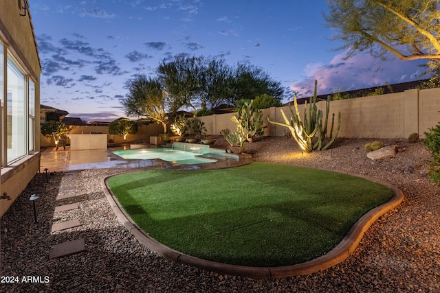 yard at dusk featuring a patio area and a fenced in pool