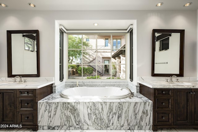 bathroom featuring vanity and tiled tub