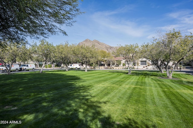 surrounding community with a mountain view and a yard