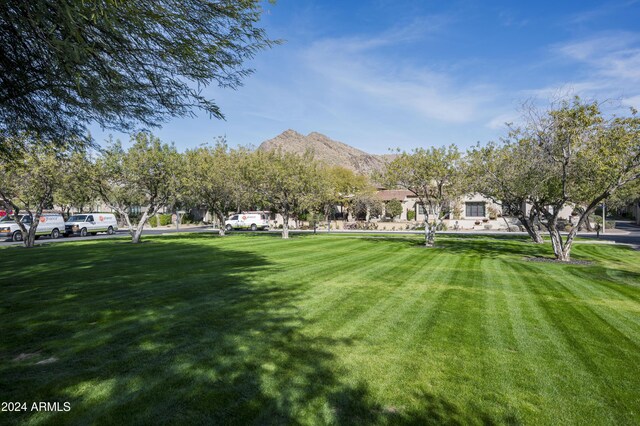 surrounding community featuring a mountain view and a lawn