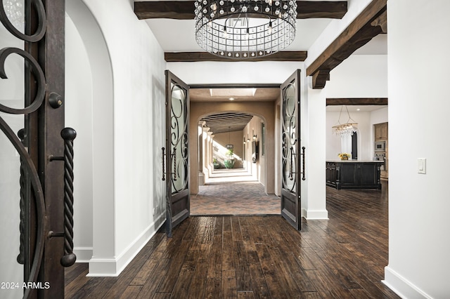 foyer with a chandelier, dark hardwood / wood-style floors, and beamed ceiling