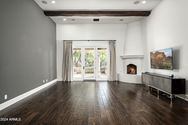 unfurnished living room featuring dark hardwood / wood-style floors, a large fireplace, and beam ceiling