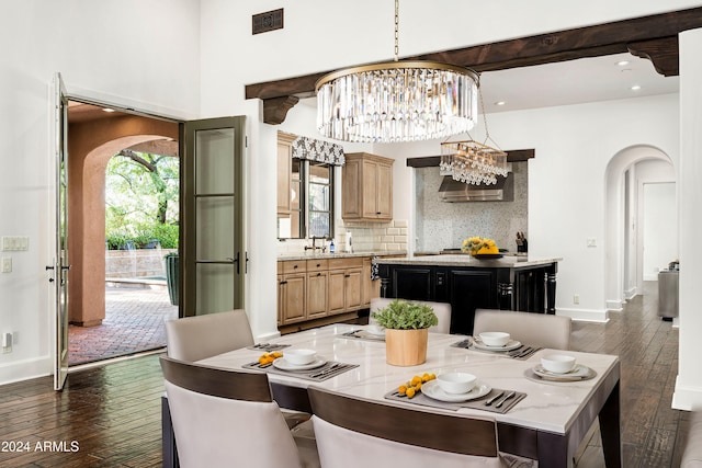 dining space with sink, dark wood-type flooring, and a notable chandelier