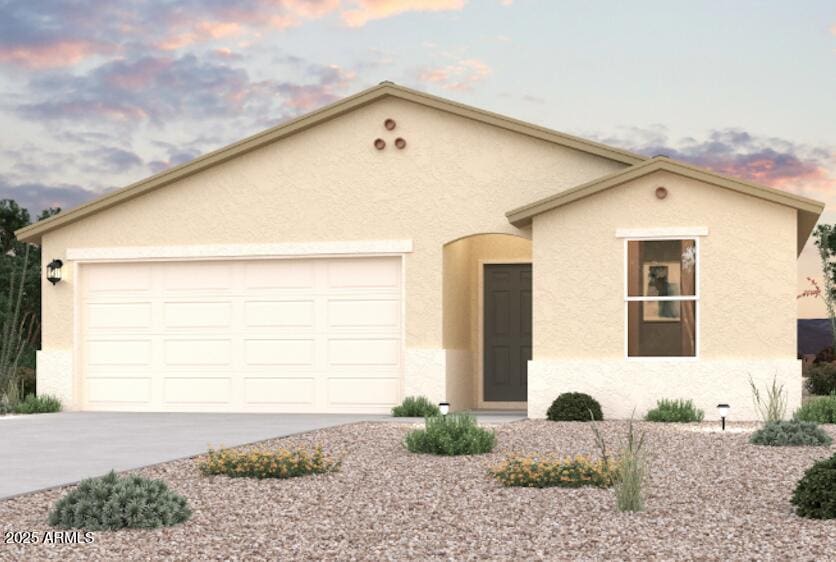 view of front of home featuring a garage, driveway, and stucco siding