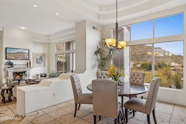 dining room featuring a mountain view, a towering ceiling, and an inviting chandelier