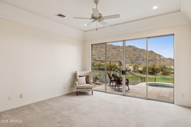 unfurnished room featuring a mountain view, carpet flooring, and ceiling fan