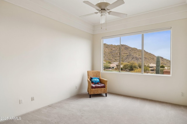 unfurnished room featuring a mountain view, carpet, and ceiling fan