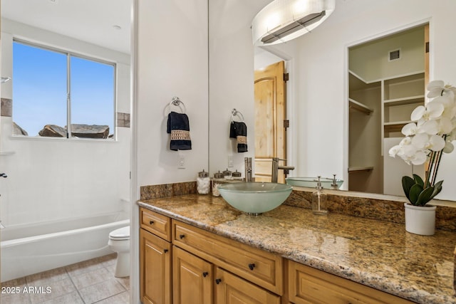 full bathroom with vanity, tile patterned floors, washtub / shower combination, and toilet