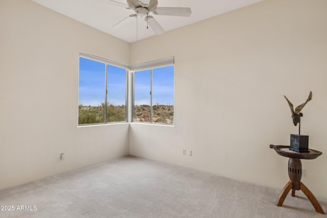 carpeted spare room with ceiling fan