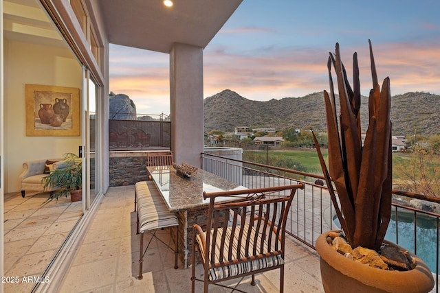 balcony at dusk featuring a mountain view