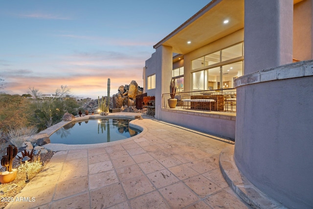 pool at dusk with a patio