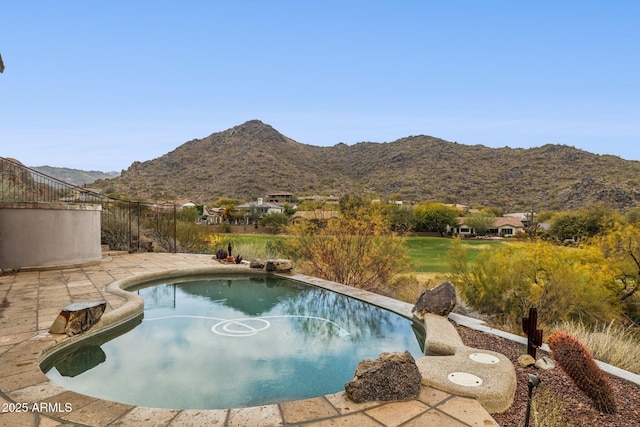 view of swimming pool with a mountain view and a patio area